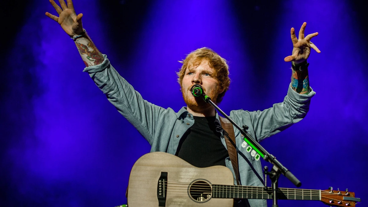 Ongemakkelijk: Ed Sheeran treedt op voor Engelse spelers, die met tegenzin toekijken