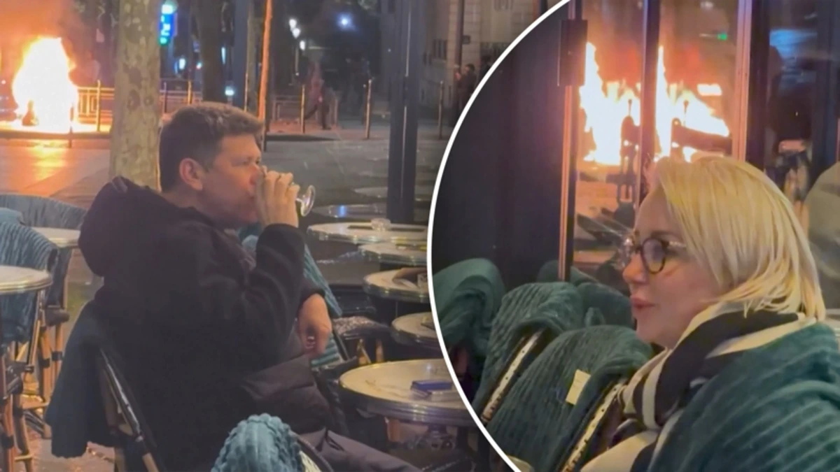 Koppel geniet van drankje alsof er niets aan de hand is tijdens Franse rellen